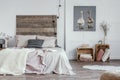 Feminine bedroom interior with rustic furniture, white walls, wooden crates and oil painting of animals. Real photo Royalty Free Stock Photo