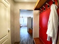 Spacious Hallway With Red Accent Wall, Wooden Doors, and Laminate Flooring. The hallway of an old poor Soviet apartment Royalty Free Stock Photo