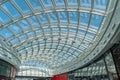 Spacious interior with a modern, minimalist building featuring an undulating glass ceiling and red-edged walkway on a gray floor Royalty Free Stock Photo