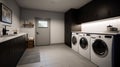 Spacious laundry room in a contemporary home with monochrome finishes in white, gray and black. Washer and dryer, sink