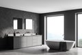 Spacious modern bathroom design interior in gray tones with concrete floor, freestanding tub, double sink vanity. Panoramic window Royalty Free Stock Photo