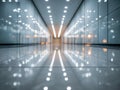 Spacious modern corridor with reflective glass walls and polished tiled floor illuminated by rows of ceiling lights creating Royalty Free Stock Photo