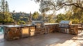 Spacious outdoor kitchen featuring grill, sink, and refrigerator illuminated by sunset glow Royalty Free Stock Photo