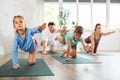 Confident mom, dad, son and daughter perform bird dog power asana