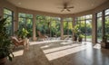 spacious sunroom with large windows, ceiling fan, and view lush garden, featuring comfortable seating and Royalty Free Stock Photo
