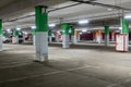 Spacious underground parking of a modern shopping center. The parking lot is marked and has many free spaces for cars