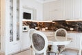 Spacious white, new kitchen with table and chairs Royalty Free Stock Photo