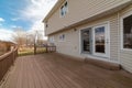 Spacious wooden deck of house overlooking the grassy backyard with playground Royalty Free Stock Photo