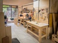 Spacious woodworking studio with tables, frames, tool racks, bright walls, power saws, and crafting stations ready for Royalty Free Stock Photo