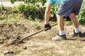 A spade in the act of digging into the soil. Senior farmer in rubber boots digging in the garden with spade. Working hands digging Royalty Free Stock Photo
