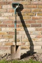 Spade leaning against Old Garden Wall Royalty Free Stock Photo