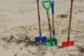 Spades digging in the sand at a beach Royalty Free Stock Photo