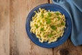 Spaetzle, homemade egg noodles served with parsley garnish on a blue plate and a rustic wooden table with copy space, traditional Royalty Free Stock Photo