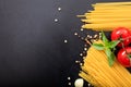 Spagetti, tomatoes and garlic on black background Royalty Free Stock Photo