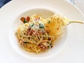 Spaghetti aglio e olio, Italian pasta with olive oil, crunchy bacon ,chili, garlic and parsley on white plate - close up view Royalty Free Stock Photo