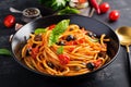 Spaghetti alla puttanesca - italian pasta dish with tomatoes, black olives, capers, anchovies Royalty Free Stock Photo