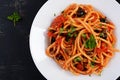 Spaghetti alla puttanesca - italian pasta dish with tomatoes, black olives, capers, anchovies Royalty Free Stock Photo
