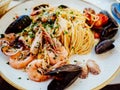 Spaghetti allo scoglio or spaghetti with seafood served in a white dish with shrimps