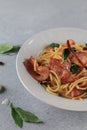 Spaghetti Bacon chili garlic basil in white plate on gray background. Popular menu classic italian cuisine dish. Royalty Free Stock Photo