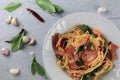 Spaghetti Bacon chili garlic basil in white plate on gray background. Popular menu classic italian cuisine dish. Royalty Free Stock Photo