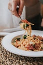 Spaghetti bacon, garlic, basil, dried chili pepper on fork on wood table. Royalty Free Stock Photo