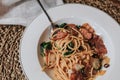 Spaghetti bacon, garlic, basil, dried chili pepper on fork on wood table. Royalty Free Stock Photo