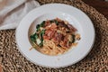 Spaghetti bacon, garlic, basil, dried chili pepper on fork on wood table. Royalty Free Stock Photo