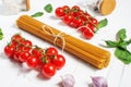 Spaghetti, basil and tomatoes isolated on white wooden table. Royalty Free Stock Photo