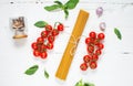 Spaghetti, basil and tomatoes isolated on white wooden table. Top view Royalty Free Stock Photo