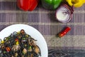Spaghetti black with seafood and vegetables on a white plate multi-colored background top view Royalty Free Stock Photo