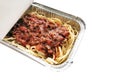 Spaghetti bolognese in aluminium foil box isolated on white background. Selective focus. Concept for take away and delivery food. Royalty Free Stock Photo