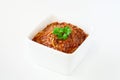 Spaghetti Bolognese with basil in white bowl