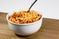 Spaghetti Bolognese in a deep white bowl on the wooden kitchen table waiting to be eaten Royalty Free Stock Photo