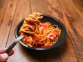 Spaghetti Bolognese on a metal fork and in black plastic container on wooden table. Premium, high quality traditional Italian Royalty Free Stock Photo