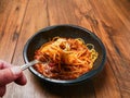 Spaghetti Bolognese on a metal fork and in black plastic container on wooden table. Premium, high quality traditional Italian Royalty Free Stock Photo