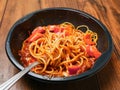 Spaghetti Bolognese on a metal fork and in black plastic container on wooden table. Premium, high quality traditional Italian Royalty Free Stock Photo