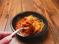 Spaghetti Bolognese on a metal fork and in black plastic container on wooden table. Premium, high quality traditional Italian Royalty Free Stock Photo