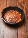 Spaghetti Bolognese ready meal in black plastic container on wooden table. Premium, high quality traditional Italian style ready Royalty Free Stock Photo