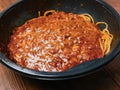 Spaghetti Bolognese ready meal in black plastic container on wooden table. Premium, high quality traditional Italian style ready Royalty Free Stock Photo