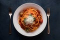 Spaghetti bolognese topped with parmesan cheese and tomatoes