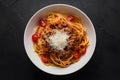 Spaghetti bolognese topped with parmesan cheese and tomatoes