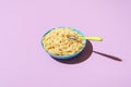 Spaghetti cacio e pepe bowl, isolated on a purple background