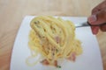 Spaghetti carbonara with cream on white plate