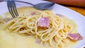 The spaghetti carbonara with fried cheese in a white plate on the table Royalty Free Stock Photo
