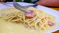 The spaghetti carbonara with fried cheese in a white plate on the table Royalty Free Stock Photo