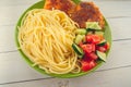 Traditional dish consisting of spaghetti with chicken cutlets and vegetable salad. Royalty Free Stock Photo
