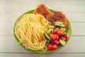 Traditional dish consisting of spaghetti with chicken cutlets and vegetable salad. Royalty Free Stock Photo