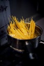 Spaghetti from durum wheat are cooked in a metal pot on the fire Royalty Free Stock Photo