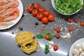 Spaghetti and fettuccine with ingredients for cooking pasta on wooden table with blank of round wooden kitchen board Royalty Free Stock Photo