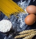 Spaghetti and flour and eggs on black background Royalty Free Stock Photo